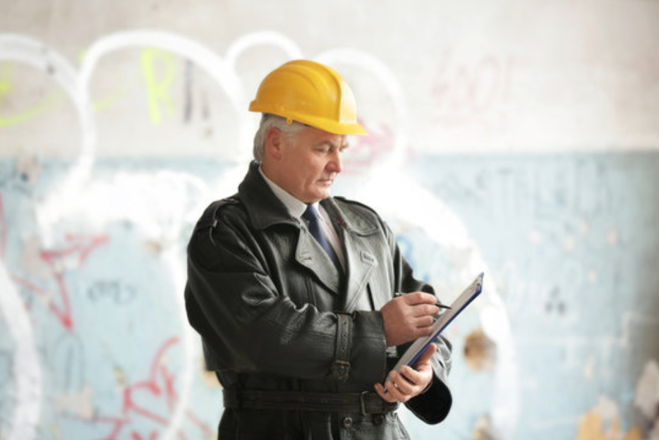 man holding clipboard with hardhat